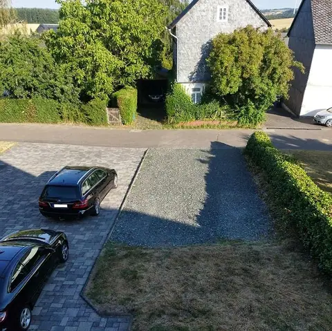 Blick vom Balkon auf die Einfahrt mit den Parkplätzen vor dem Haus