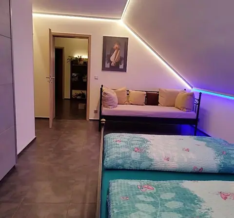 Schlafzimmer 1 mit Doppelbett und Futon unter der beleuchteten Dachschräge