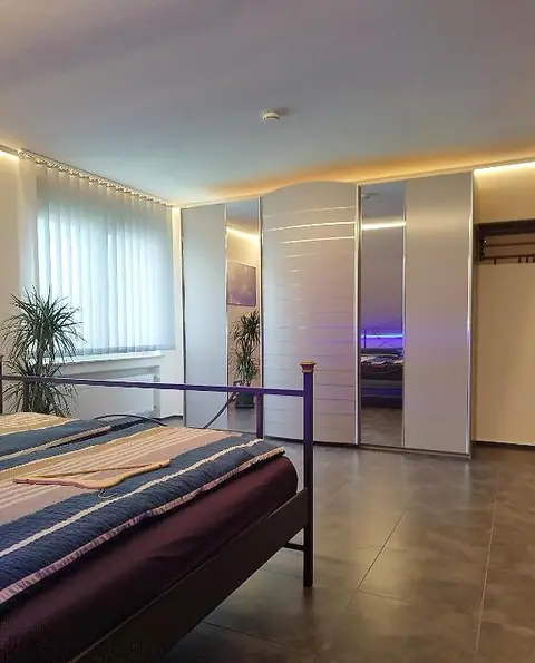 Schlafzimmer 2 mit Metall-Doppelbett und Kleiderschrank mit Spiegeltüren