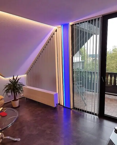 Balkontür im Wohnzimmer mit LED-Lichtband und Blick ins Grüne